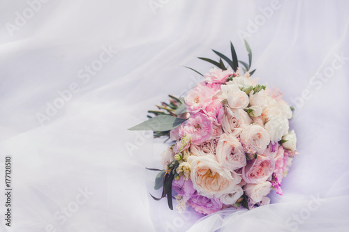 Fototapeta Naklejka Na Ścianę i Meble -  A wedding bouquet of asters and dahlias and roses on a snow-white dress on a sunny day close-up
