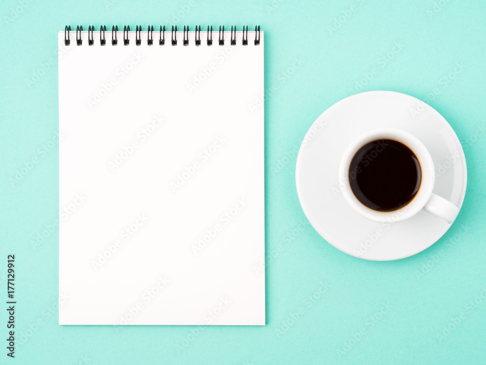 Notepad open with white blank page for writing idea or to-do list, a Cup of coffee on bright blue background Notepad open with white blank page for writing idea or to-do list, a Cup of coffee on bright blue background