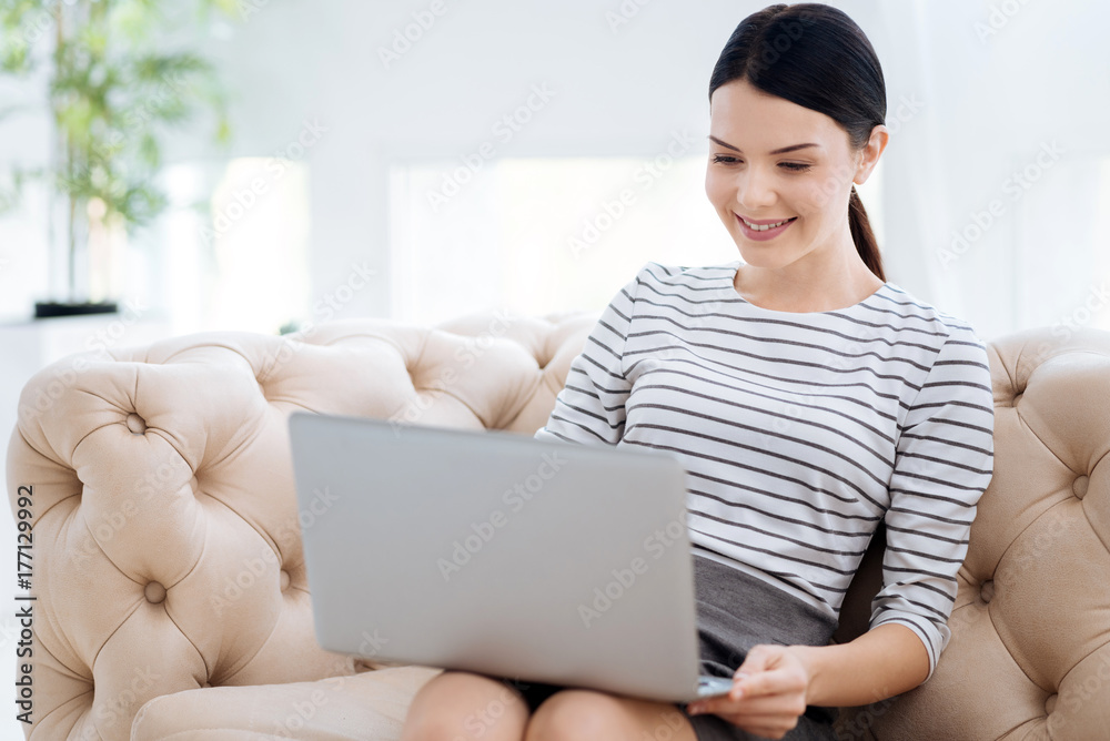 Happy young woman looking at the laptop screen Happy young woman looking at the laptop screen