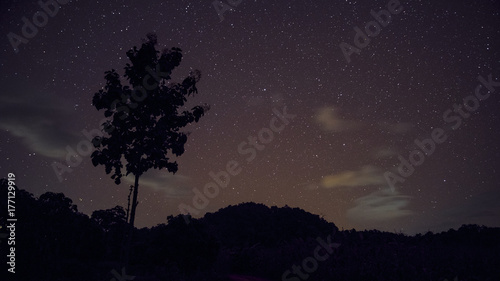 Long exposure and High ISO shot of star and milky way over the mountain at night. red tone effect.