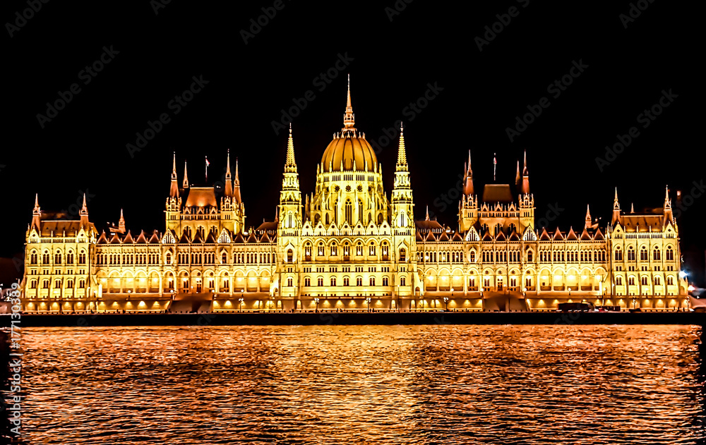 Budapest Parliament in Hungary at night on the Danube river.