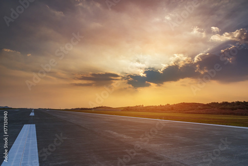 Runway  airstrip in the airport terminal with marking on blue sky with clouds background. Travel aviation concept.