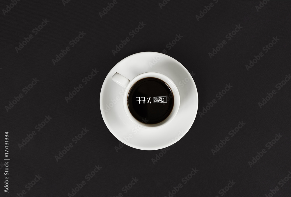 Coffee in white cup with a lettering 77 charge on black slate background Coffee in white cup with a lettering 77 charge on black slate background