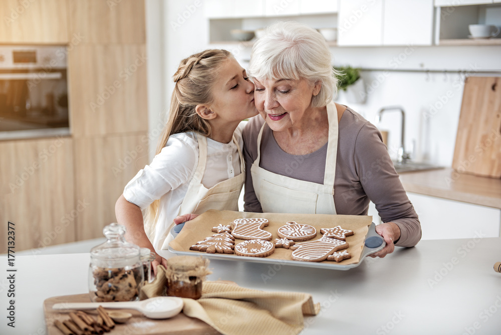Happy child thanking grandma for sweet pastry - obrazy, fototapety, plakaty 