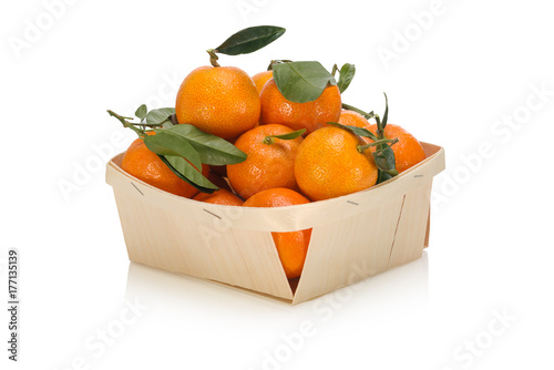 Basket of  freshly picked tangerines with leaves isolated on white background photo