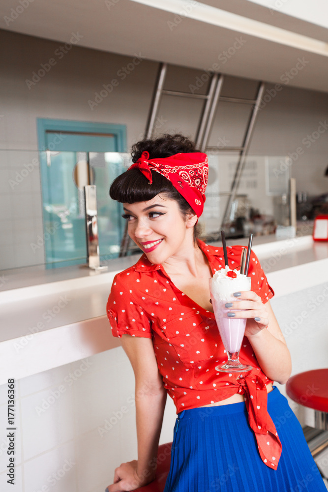 Handsome female in stylish retro outfit with milkshake at diner restaurant.  Stock Photo | Adobe Stock