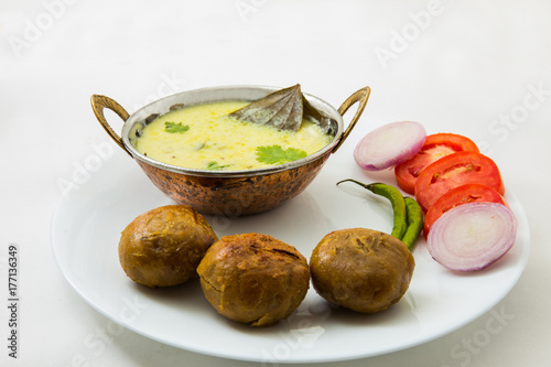 Tradtional Rajsthani food Kadi Bati or Dal Bati served with salads - tomato, onion and green chilli photo