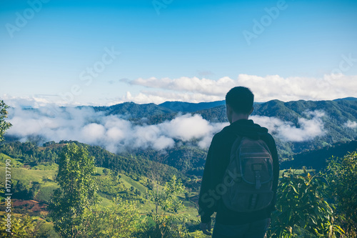 Carefree happy man enjoying nature on top of mountain cliff with sunrise. Freedom concept. Sunbeams. Enjoyment. © doidam10