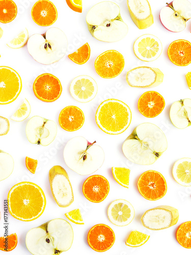 Food pattern of fresh fruit in a cut. Oranges, lemons, bananas, apples, tangerines slices. Top view, flat lay. Citrus fruits background, wallpaper.