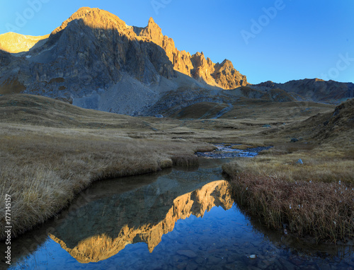 Mountain peaks refelcted in a small stream during an autumn sunset.