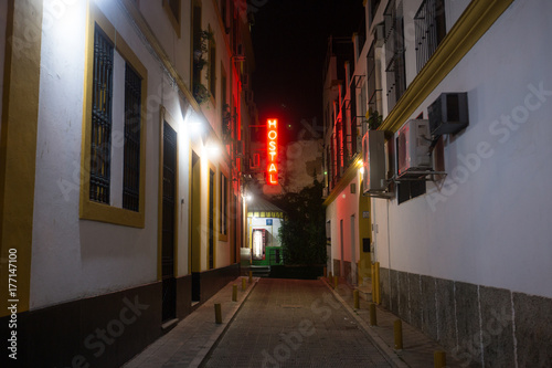 Neon backpacking hostel sign in European city alley photo