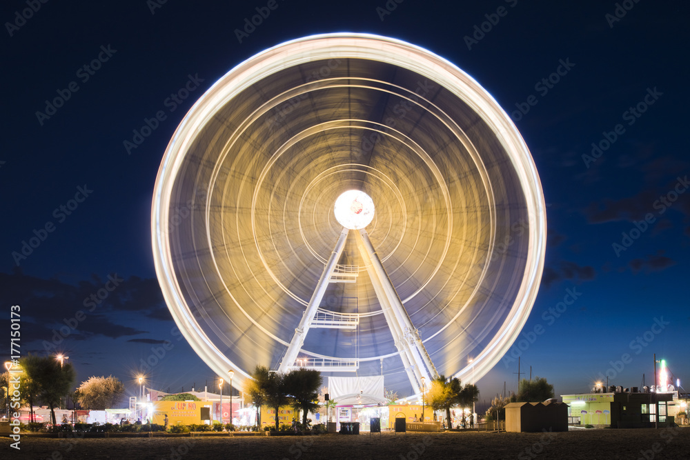 Spinning ferris panoramic wheel lights at dusk night Rimini Italy Europe
