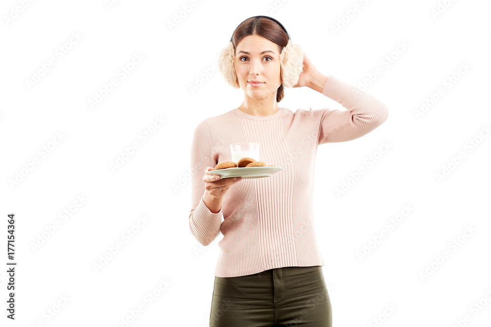 Studio portarit of young woman in earmuffs holding plate with biscuits Studio portarit of young woman in earmuffs holding plate with biscuits