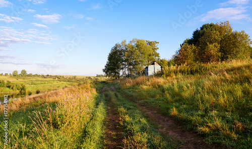 Sunny summer landscape with ground countryside road