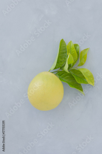oranges, lime, lemon with green leaves on a gray texture background top view. still life with citrus on a dark background.