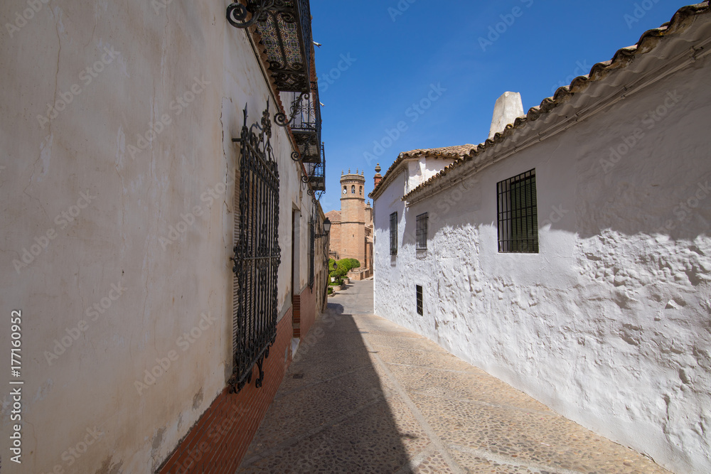 landmark ancient street and bell tower in old town of Banos de la Encina village, in Jaen, Andalusia, Spain Europe

