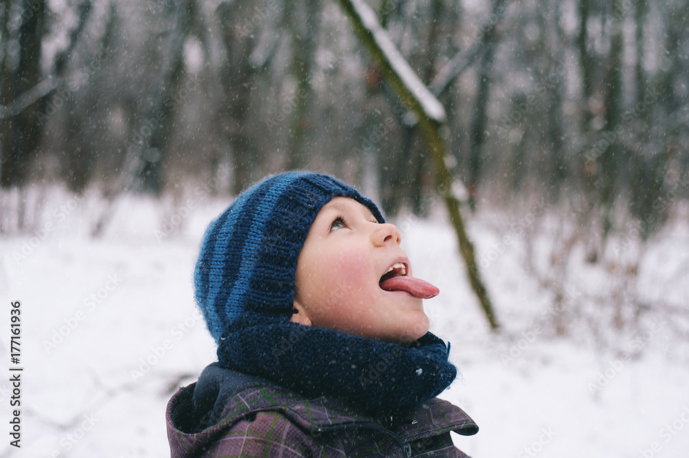 Boy trying to catch snowflakes with his tongue Boy trying to catch snowflakes with his tongue