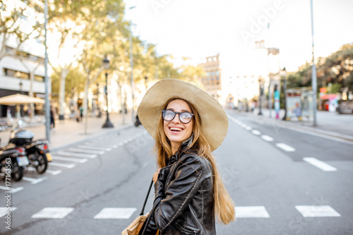 Young woman tourist in hat walking on the famous pedestrian boulevard in Barcelona city