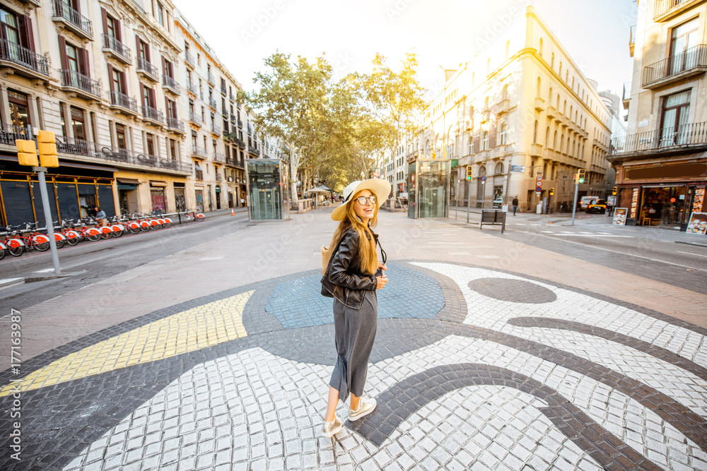 Obraz premium Young woman tourist standing on the central street with famous colorful tiles in Barcelona city