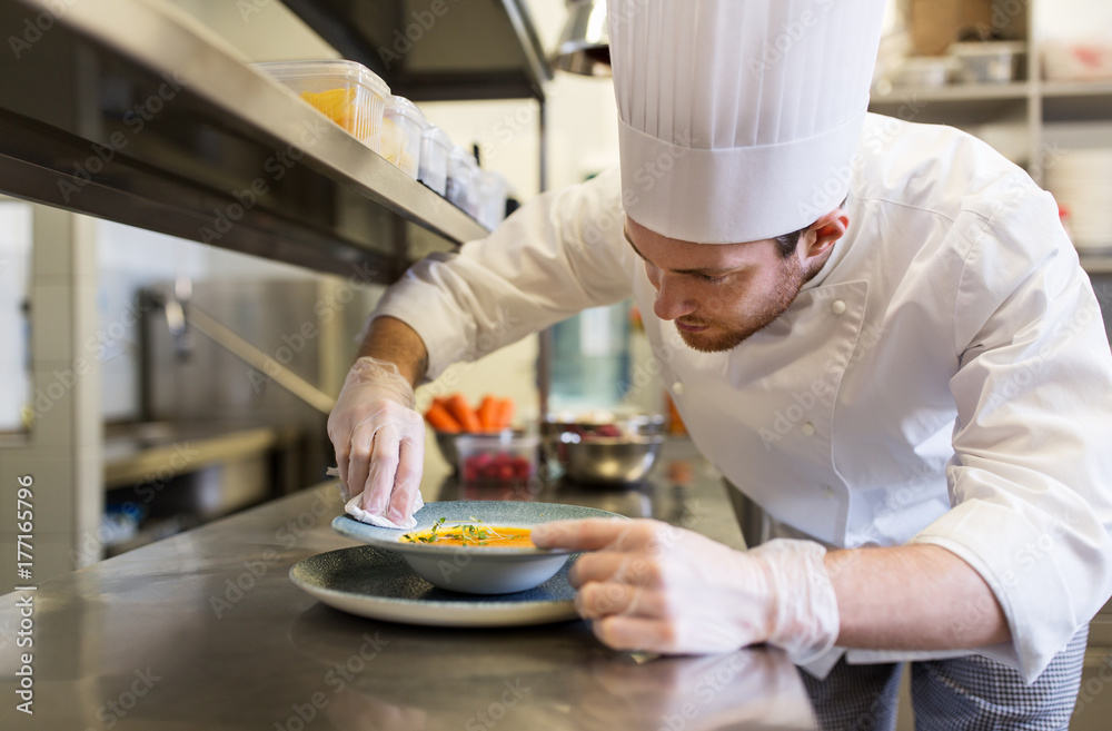 happy male chef cooking food at restaurant kitchen happy male chef cooking food at restaurant kitchen