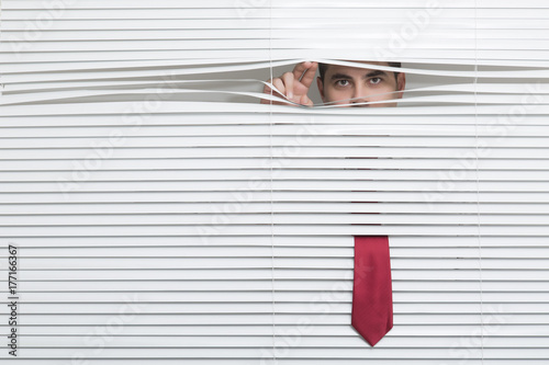 Man Watching through window blinds