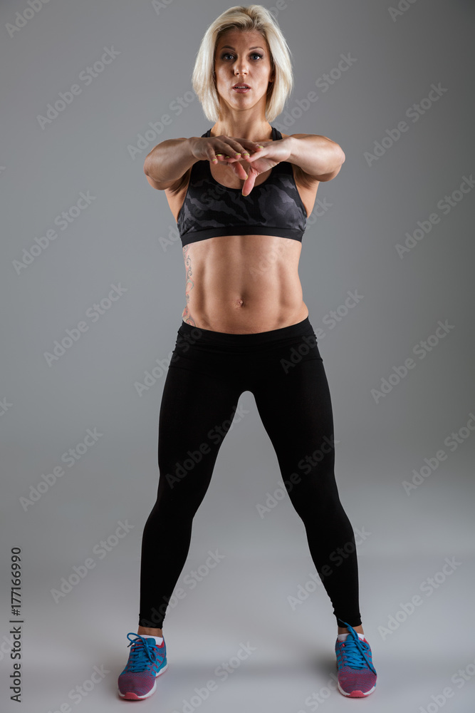 Full length portrait of a concentrated muscular adult sportswoman Full length portrait of a concentrated muscular adult sportswoman