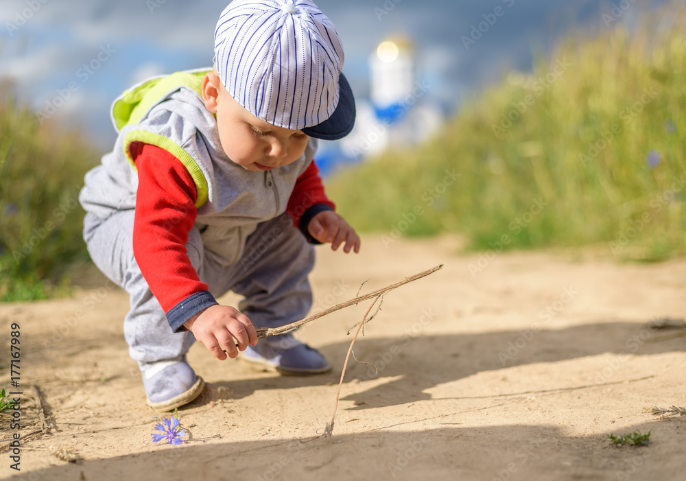 little boy in the field on the background of the church 