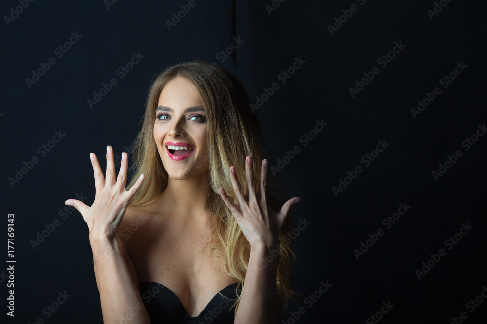 beautiful young girl with a surprised and joyful emotion on her face on a black background beautiful young girl with a surprised and joyful emotion on her face on a black background
