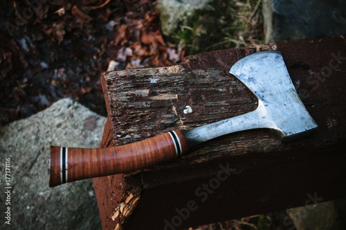 Sharp hatchet hand tool on old wood photo