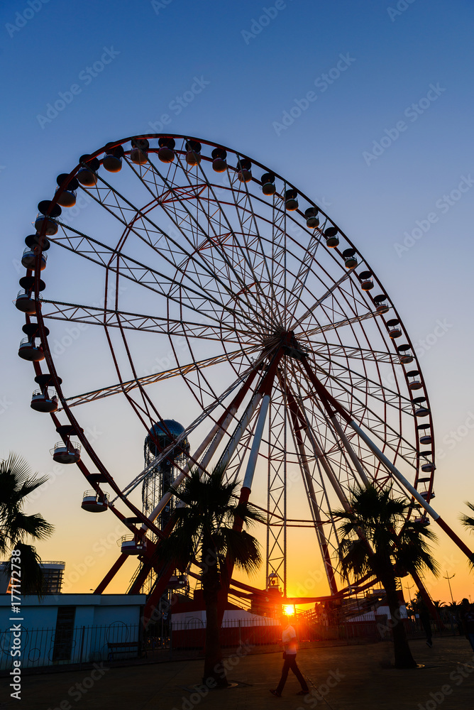 Ferris wheel on amazing sunset sky background