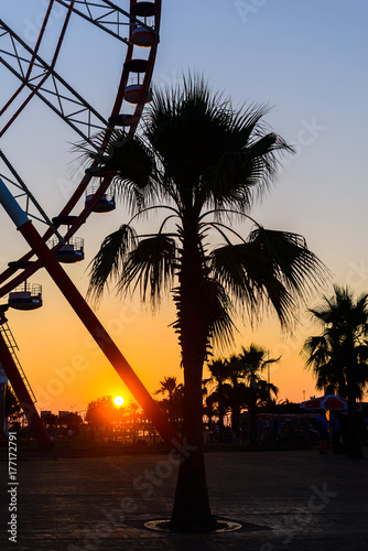 Ferris wheel on amazing sunset sky background
