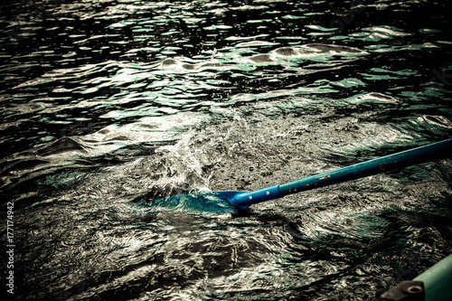 Paddle from the boat put in the water. Paddle blue colors. 