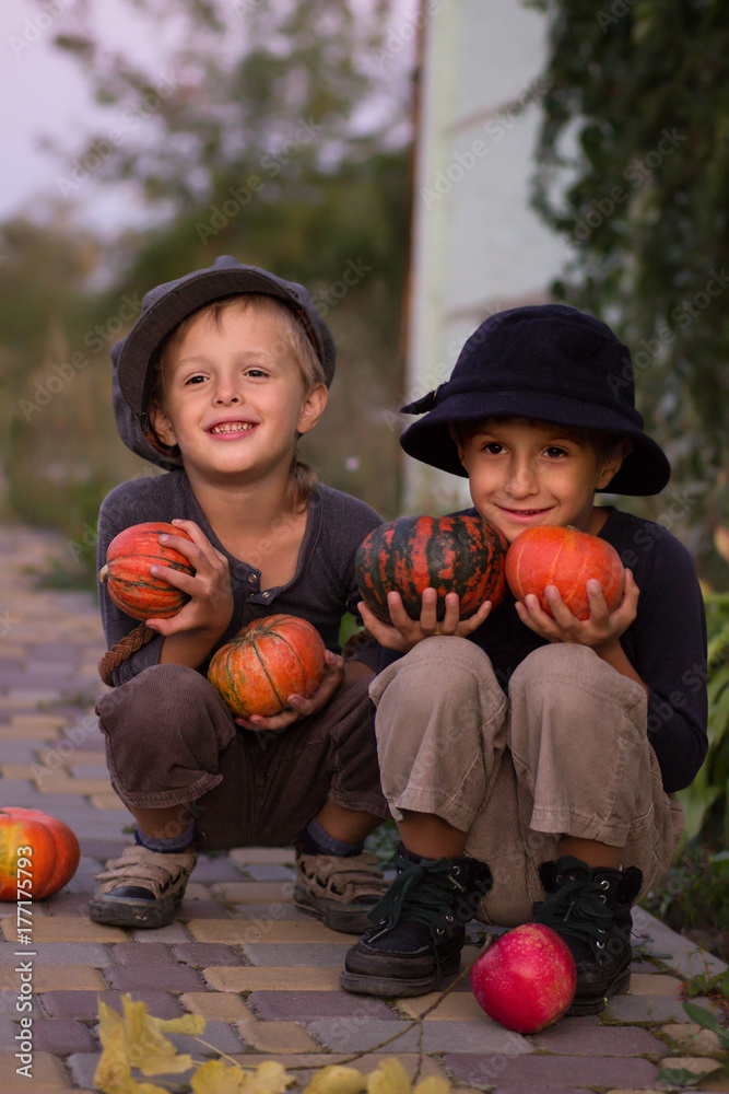 Fototapeta premium Nice kids sitting with Halloween pumpkins