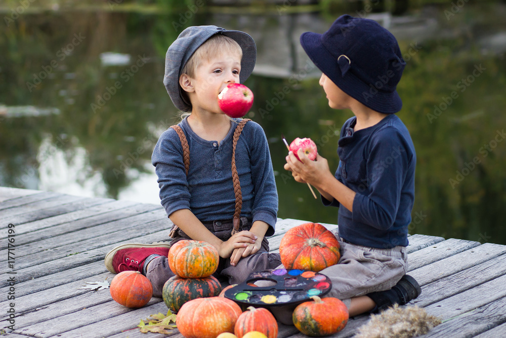 Fototapeta premium Nice boys sitting with pumpkins and apples