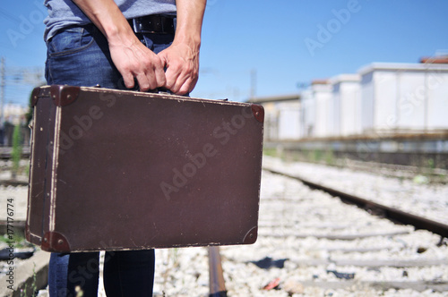 young man with a suitcase on the railroad photo