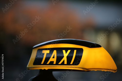 Taxi sign on taxi car with blurred city background, selective focus copy with space