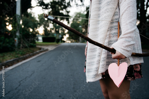 Girl holding a bow and heart shaped arrow