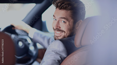 Portrait of an handsome smiling business man driving his car © ASDF
