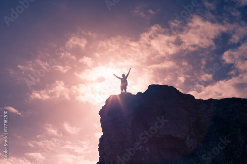 Man celebrating on top a mountain peak. Victory, challenge concept