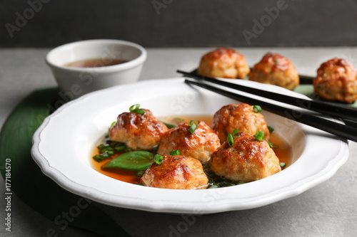 Delicious meatballs with sauce in plate on table