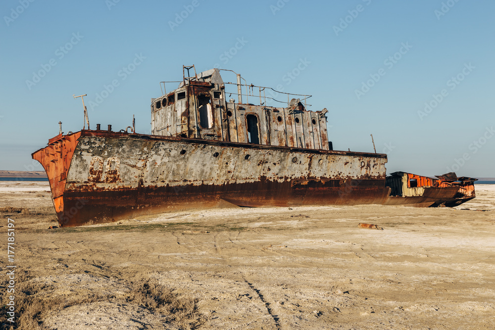Aral sea disaster. Abandoned rusty fishing boat at the desert on the place of former Aral sea
