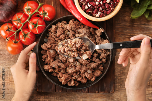 Photography Woman stirring cooked minced meat in kitchen