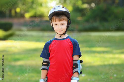 Cute boy rollerskating in park
