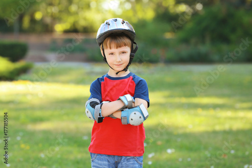 Cute boy rollerskating in park