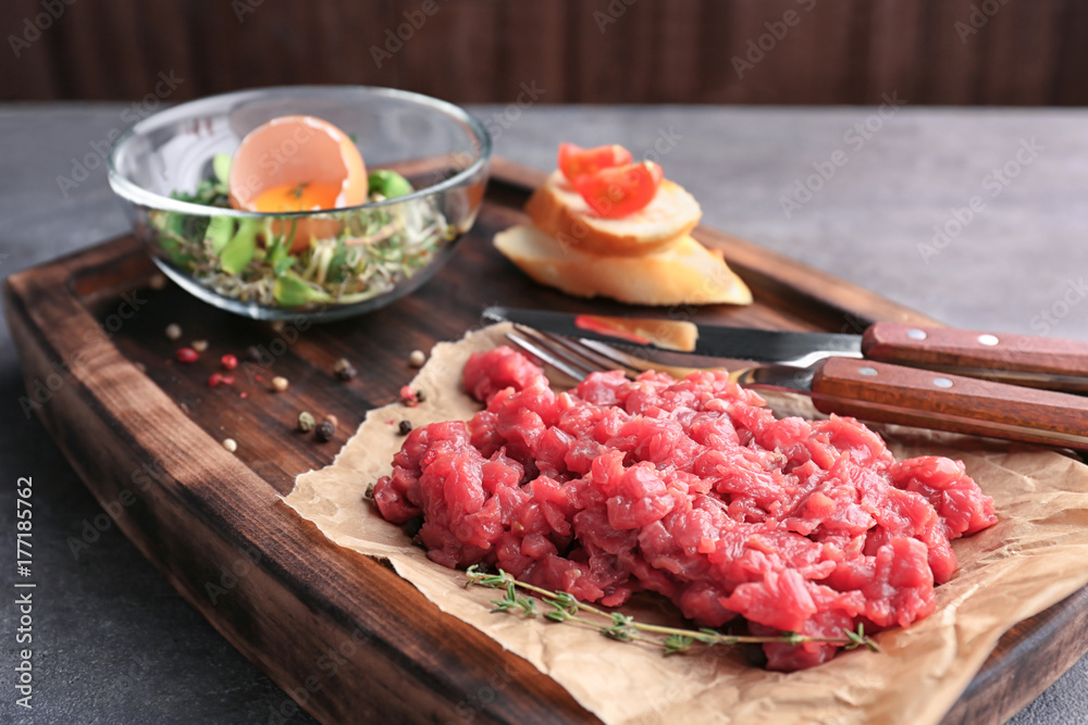 Delicious steak tartare on wooden board