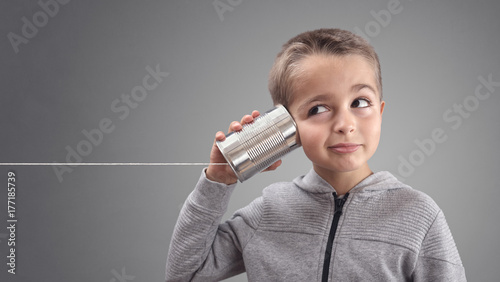 Obraz na plátně Boy on tin can phone listening to curious good news