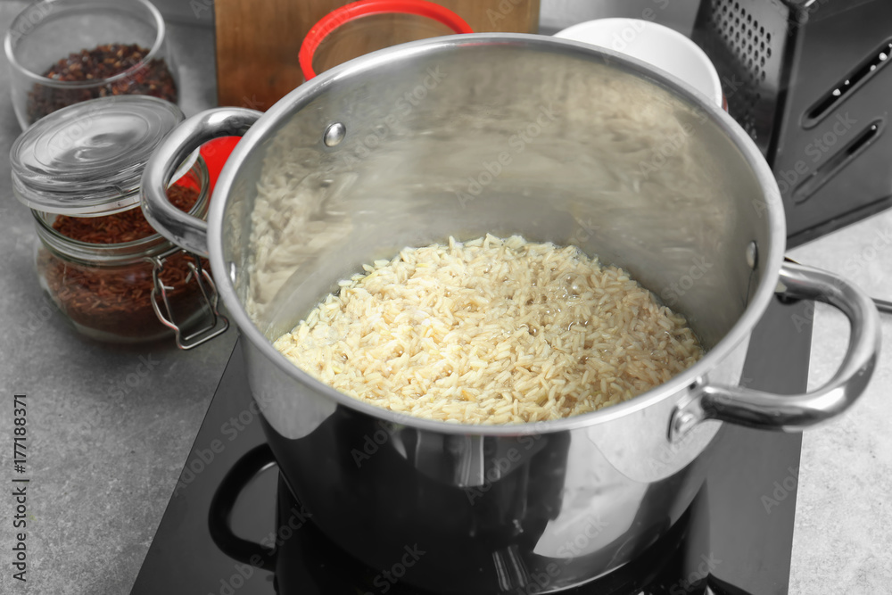 Stewpot with boiling rice in kitchen