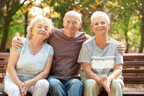 Elderly people sitting on b...