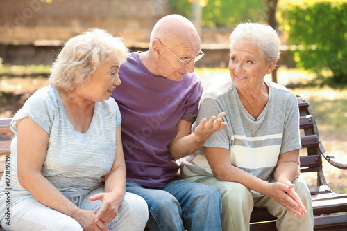 Elderly people sitting on bench in park