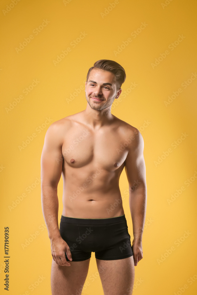 Sexy shirtless man in underwear on color background